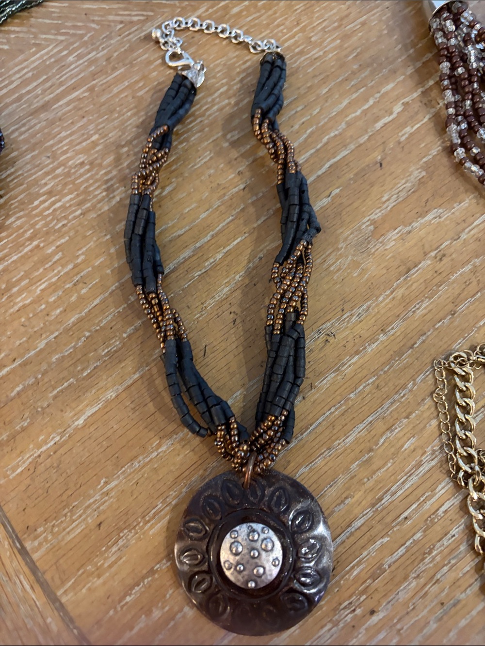 This is a Chicoโs glitter sunflower Black and Bronze Beaded Pendant Necklace.